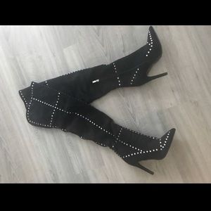 Black thigh high boots with silver studs.